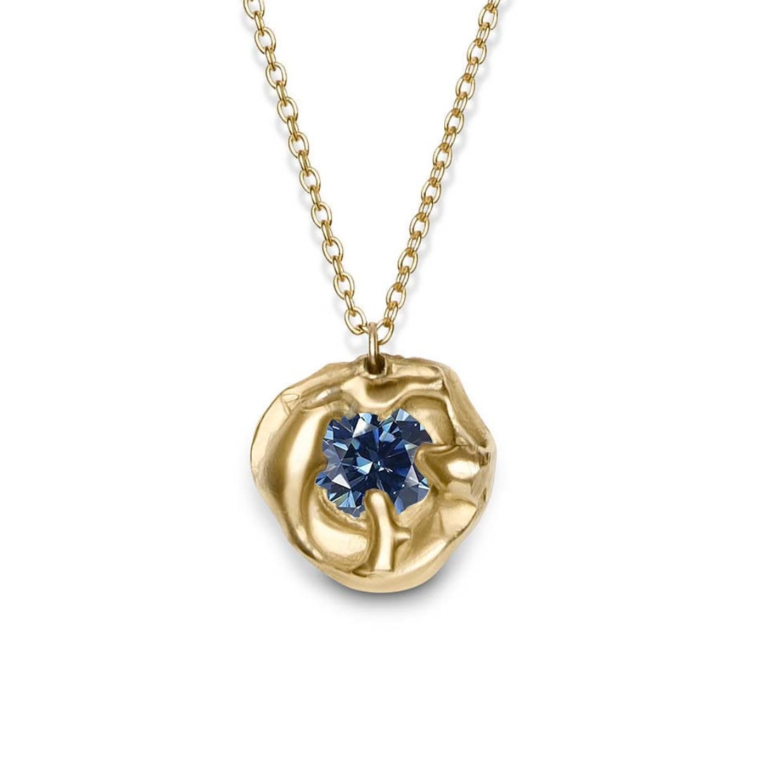The Molten Necklace with Moissanite by Madeleine Sculptural Jewellery features a textured, irregular gold pendant set with a central moissanite on a simple gold chain—a striking handmade piece shown against a white background.