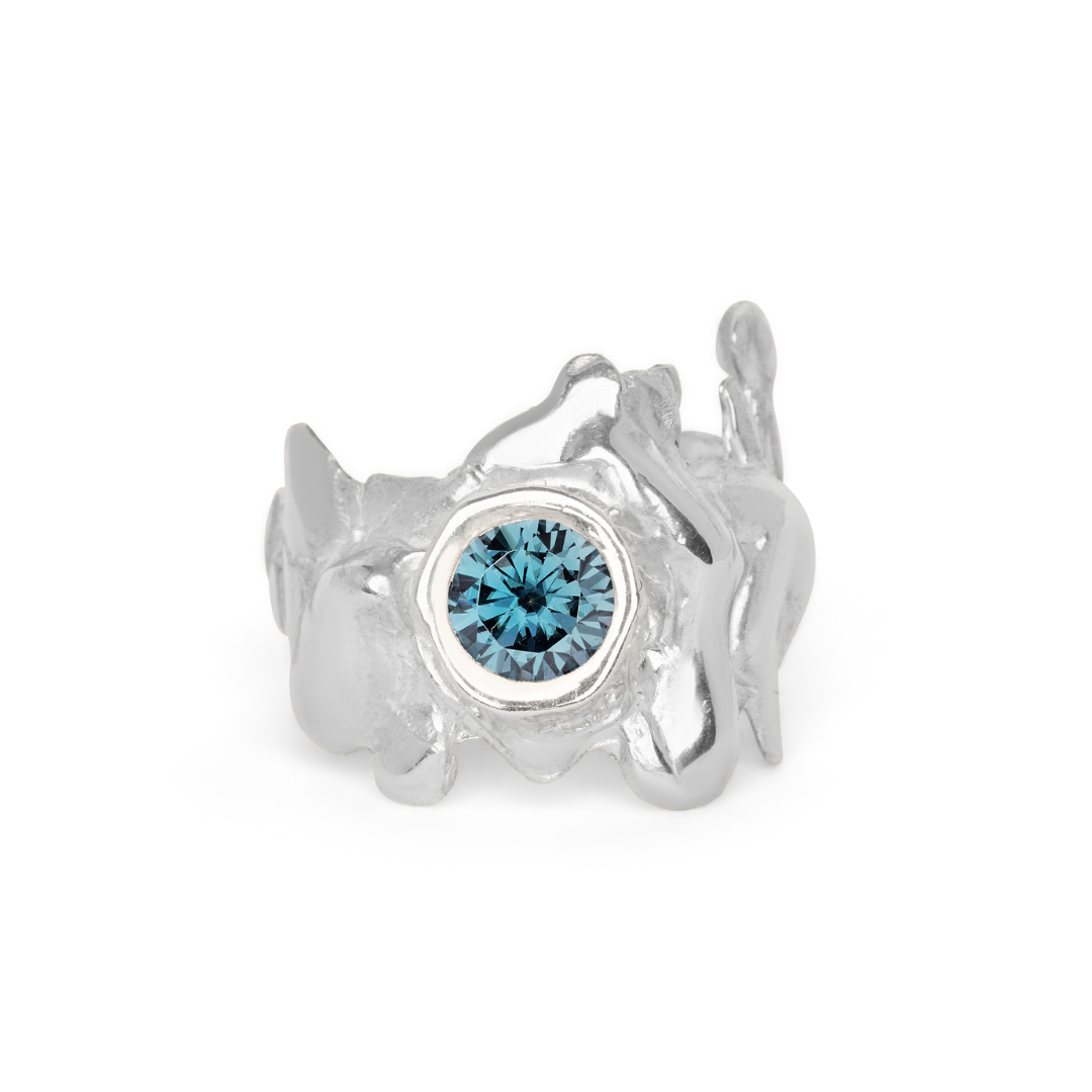 Introducing the Solstice Ring with Large Moissanite from Madeleine Sculptural Jewellery—a silver ring featuring an abstract, organic design and a brilliant round moissanite centerpiece, perfect for those seeking unique, custom-made jewelry.