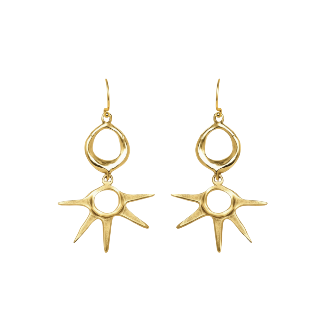 Realta Earrings by Madeleine Sculptural Jewellery: Gold dangle earrings featuring circular loops at the top and sunburst-shaped pendants with eight irregular rays, displayed on a white background.