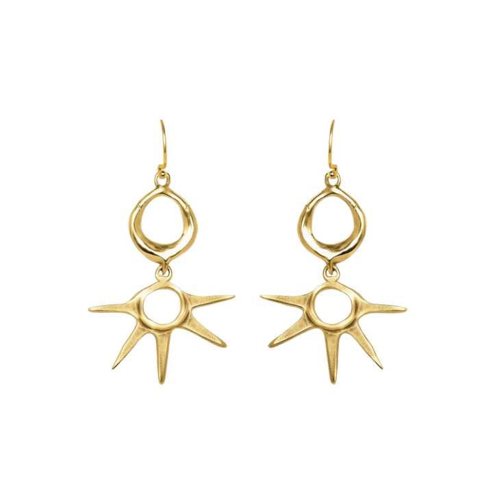 Realta Earrings by Madeleine Sculptural Jewellery: Gold dangle earrings featuring circular loops at the top and sunburst-shaped pendants with eight irregular rays, displayed on a white background.