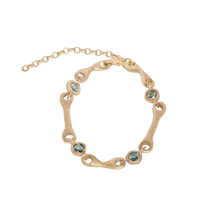 Introducing the Madeleine Blaine Relic Bracelet: an exquisite gold bracelet featuring an adjustable chain, distinctive wavy links, and six round green gemstones. This stunning piece of gemstone jewelry perfectly blends timeless elegance with modern design.