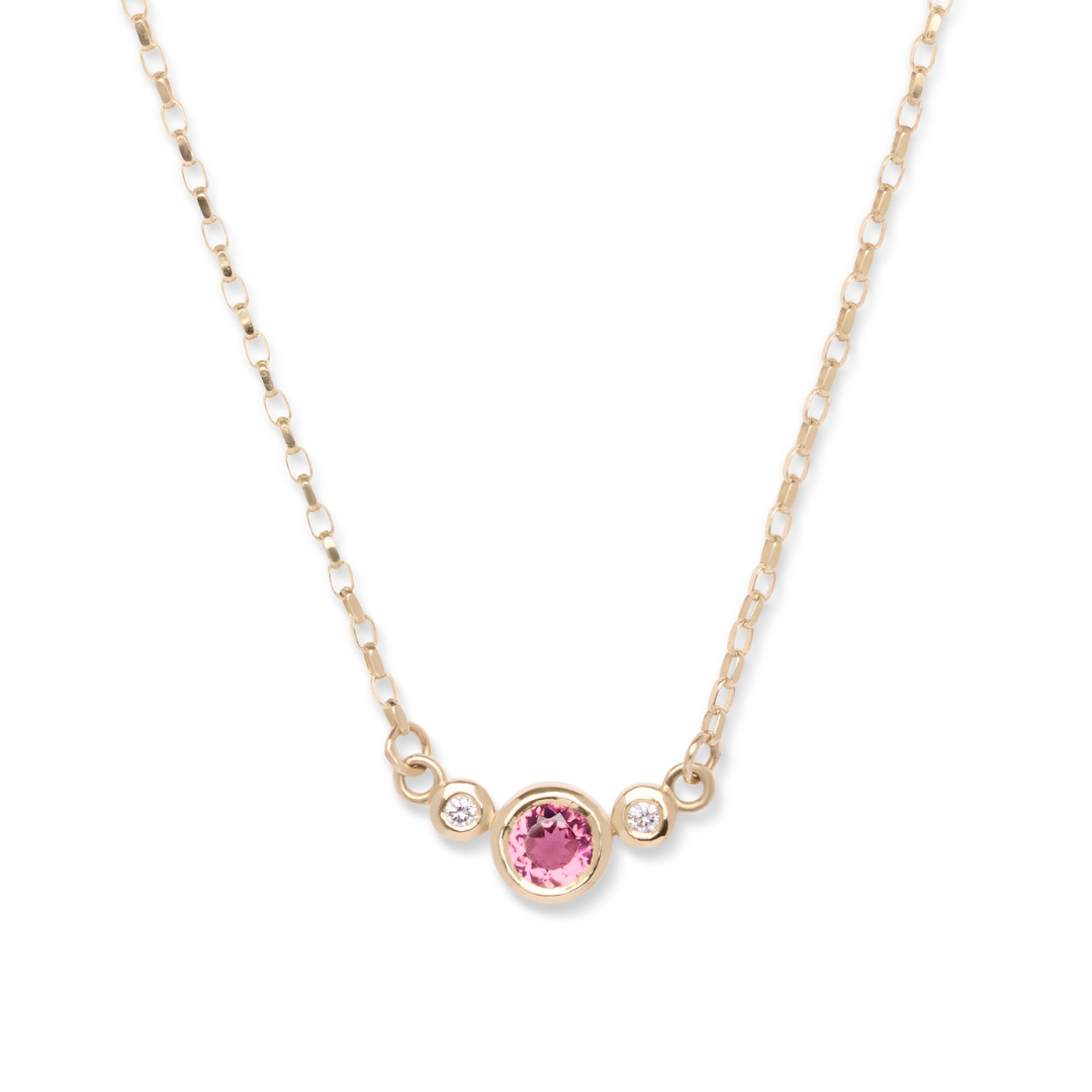 Introducing the Rose Embrace 9ct Yellow Gold Necklace with Two Diamonds by Madeleine Fine Jewellery, featuring a central round rose pink tourmaline gemstone beautifully set in yellow gold bezels, elegantly accented on each side by sparkling lab grown diamonds.