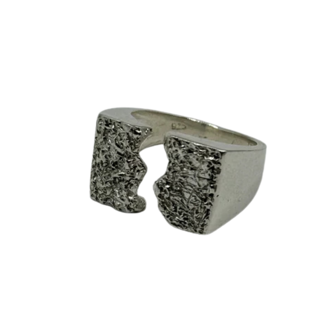 The Majesty Ring by Inó Jewellery is a handcrafted silver signet with a wide band, open front, and jagged textured edges creating a bold split design. Photographed against a plain white background.