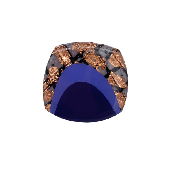 The Rothlú M'anam Cocktail Ring showcases a square design with a deep blue base and an upper half featuring metallic copper flakes set in a speckled light gray background.
