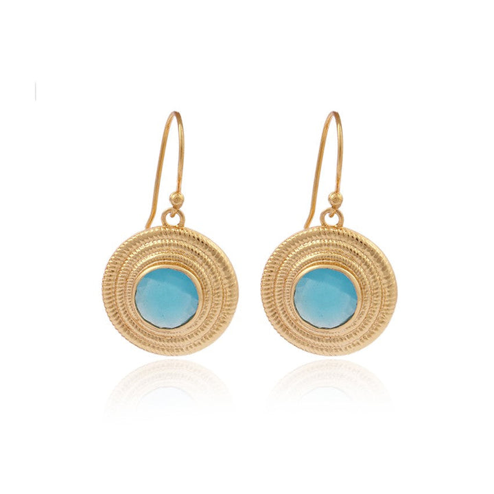 Melissa Blue Chalcedony Earrings, crafted in a Mediterranean style, feature a central turquoise stone and are attached to thin hooks. The textured gold plate on sterling silver complements the blue stones, creating an elegant accessory. Displayed against a white background by Watermelon Tropical.