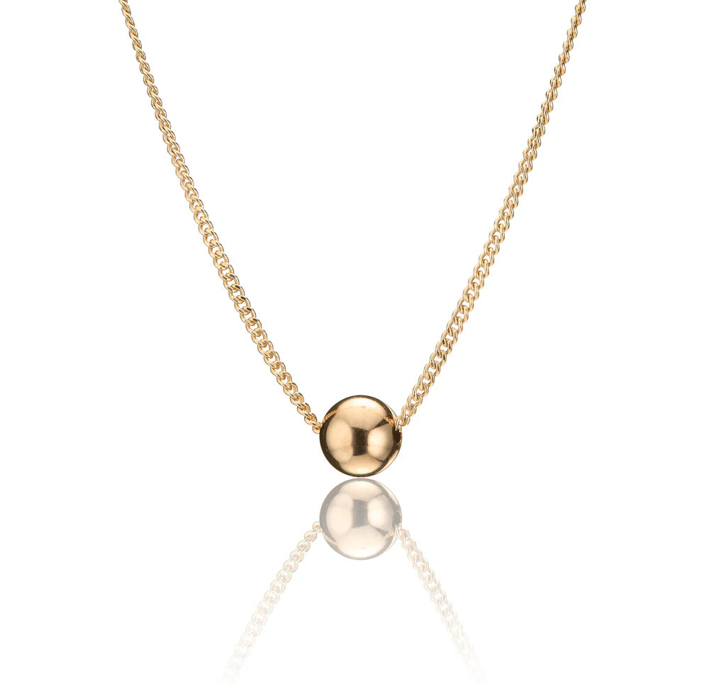 Gold necklace with a round pendant and curb chain on a white background