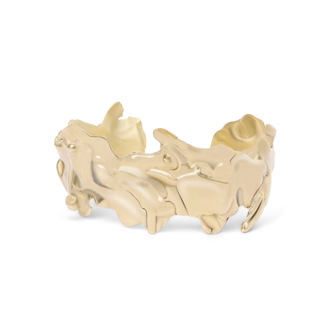 The Molten Cuff by Madeleine Sculptural Jewellery is a handmade gold bracelet with an organic, textured design, uneven edges, and a polished finish—an eye-catching statement piece.