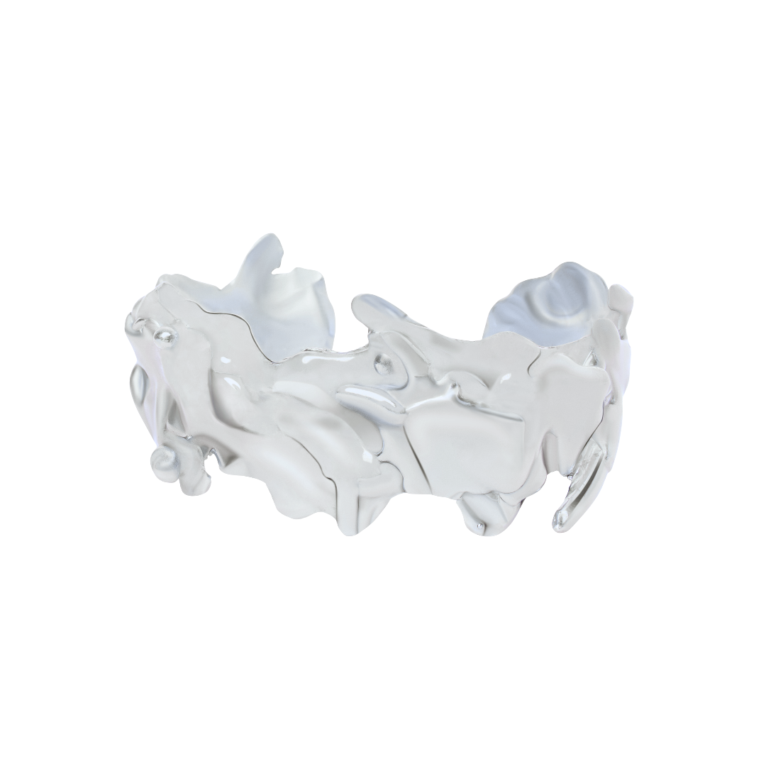 The Molten Cuff by Madeleine Sculptural Jewellery is a silver bracelet featuring an abstract, wavy, and irregular surface, handcrafted sustainably. Displayed on a white background.