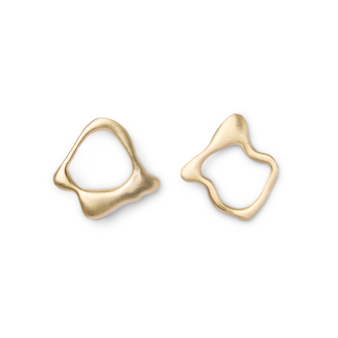 The Asymmetrical Molten Studs by Madeleine Sculptural Jewellery feature abstract, gold, wavy-edged forms with subtle textures, displayed on white. Their irregular, organic shapes evoke a modern, artistic appeal.