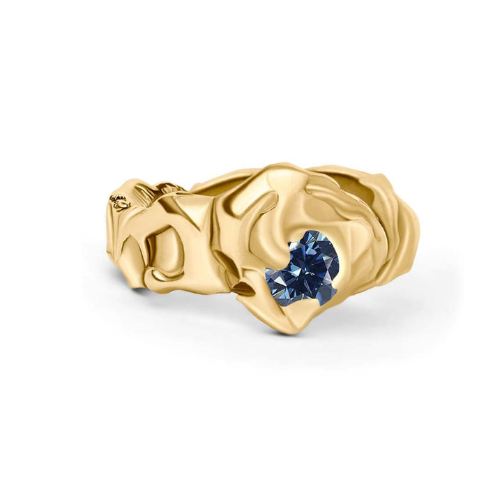 The Molten Ring with Moissanite by Madeleine Sculptural Jewellery features an organic, hand-carved gold band set with a sparkling moissanite—an elegant example of sculptural design.