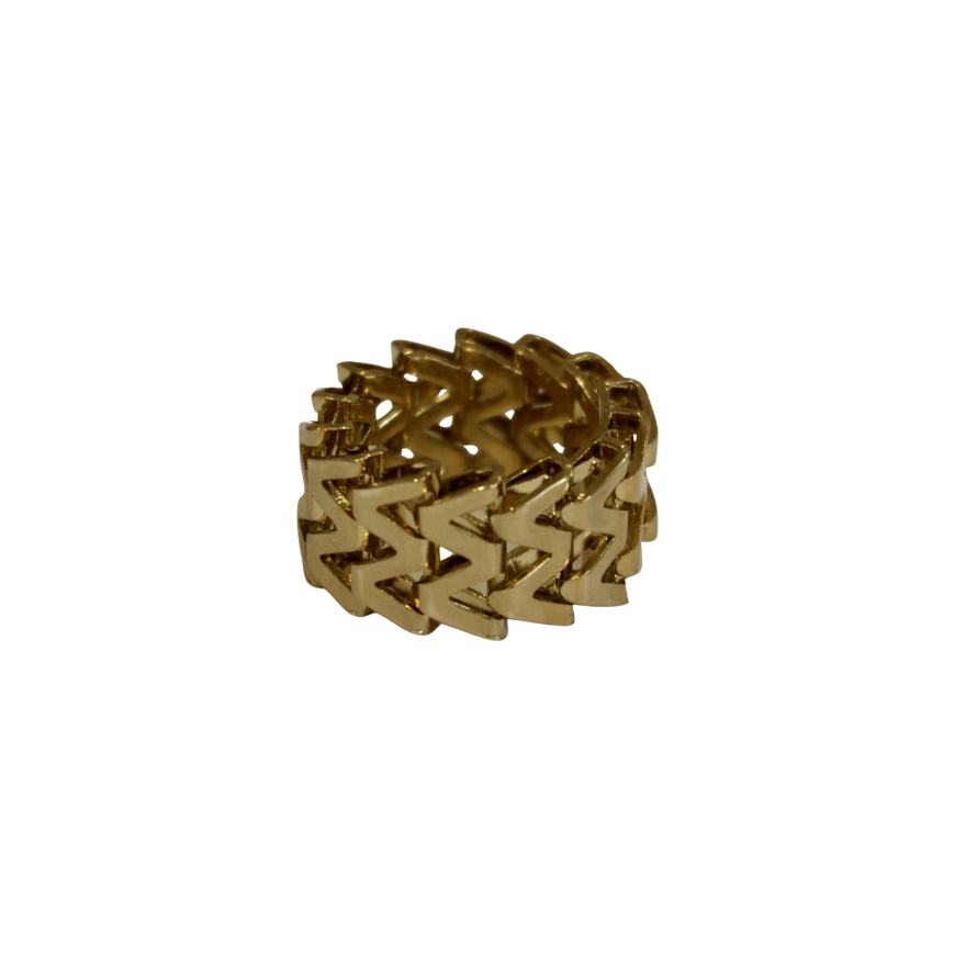 The Zubeldia W Motif Gold Plated Ring features a wide brass band with a repeating chevron pattern, inspired by Hélène Zubeldia, and is displayed on a white background.