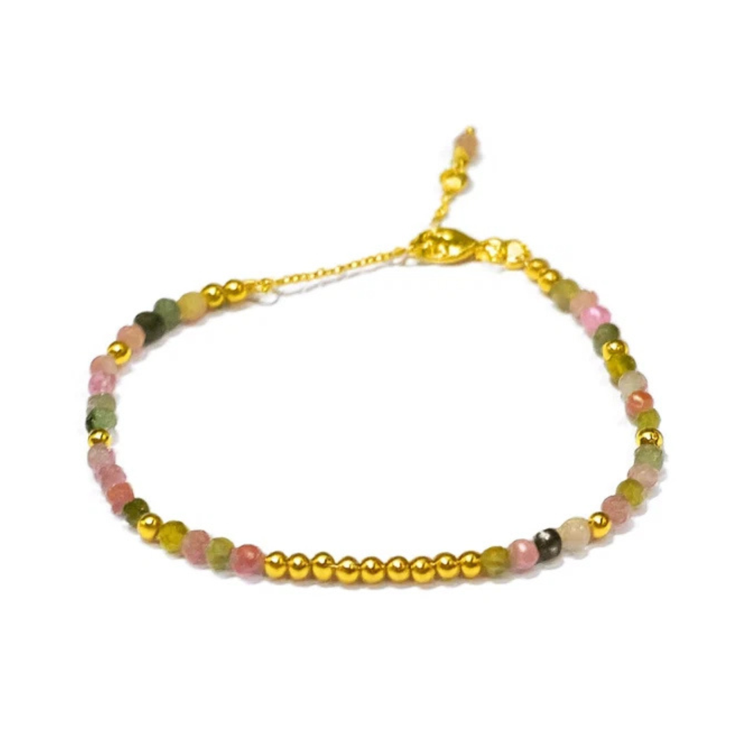 The Watermelon Tropical Multi Tourmaline Gold Bracelet features delicate gold plating, small gold beads, and multicolored tourmaline gemstones in pink, green, and beige with an adjustable gold chain clasp, shown on a white background.