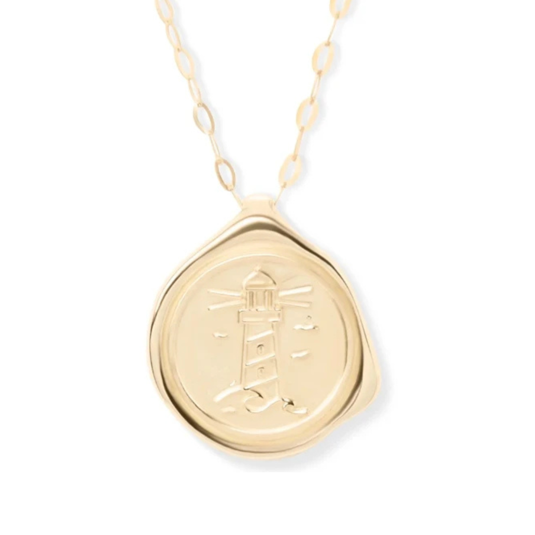 Introducing the "My Guiding Light Gold Plated Pendant" by Ava Jane Jewellery—a gold necklace showcasing a round pendant engraved with a lighthouse design and surrounded by wavy etched lines reminiscent of a wax seal. This meaningful keepsake is suspended from an elegant chain featuring elongated oval links.