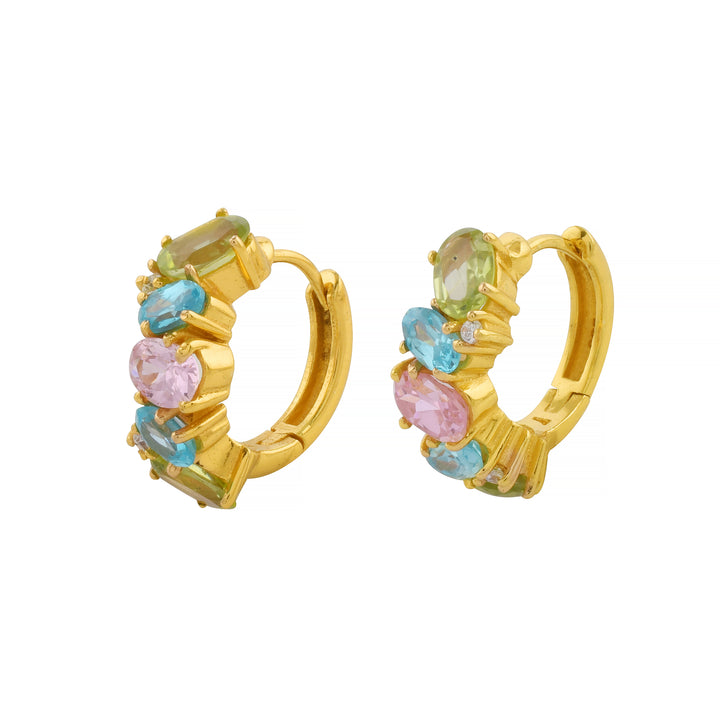 A pair of Shyla Nila Huggies adorned with an assortment of colorful gemstones, including green, blue, and pink stones, arranged in an elegant pattern. These gold earrings have a vibrant and luxurious appearance.