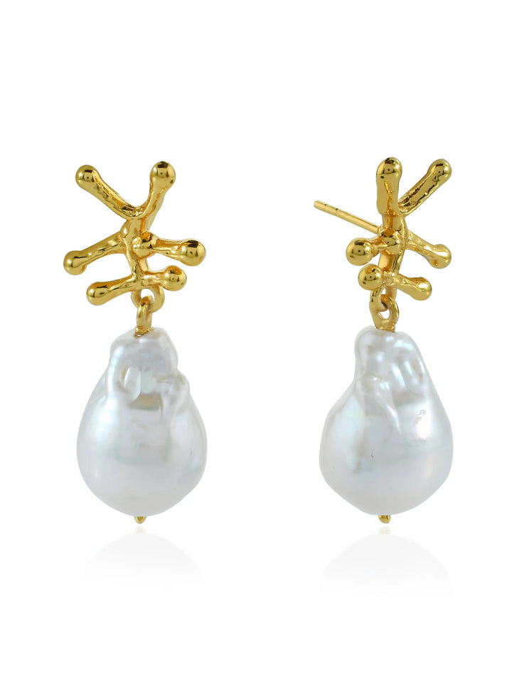 Introducing the Nuria Earrings from Shyla, a pair of gold-colored earrings featuring an abstract, branch-like design at the top, from which large, irregularly shaped Baroque pearls dangle. The earrings have a modern, artistic appeal with a mix of asymmetrical lines and organic forms.