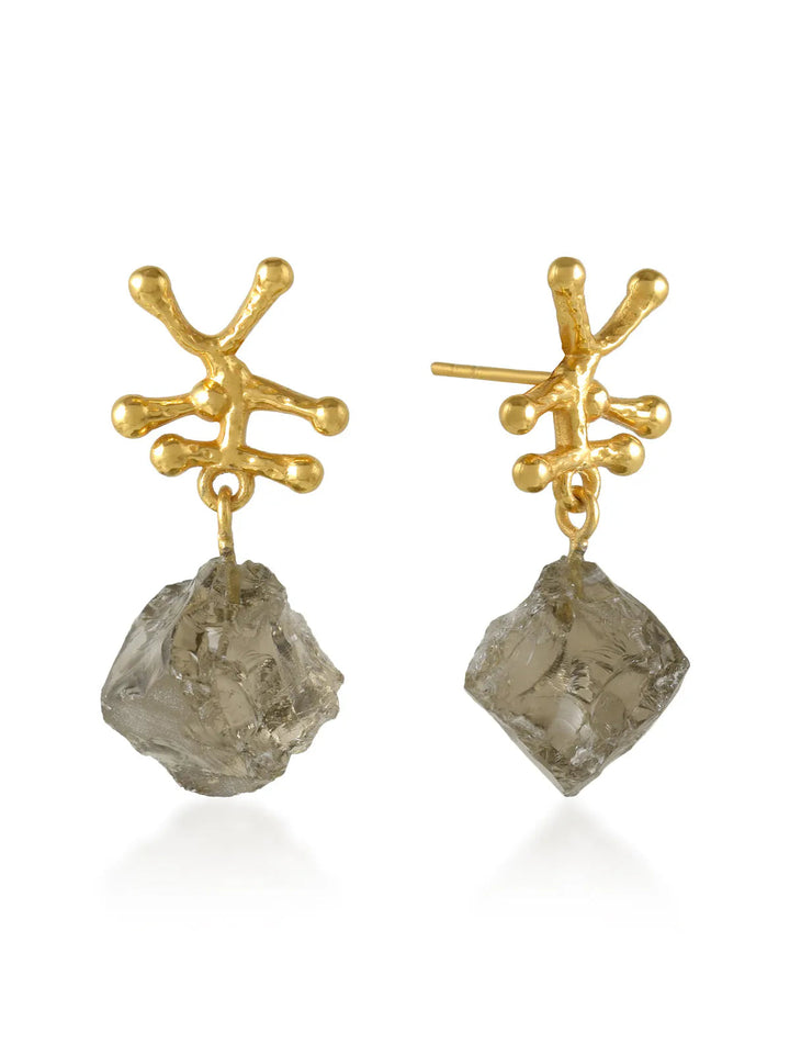 Introducing the Nuria Earrings by Shyla: a pair of chic gold stud earrings featuring irregularly-shaped branches with small spherical ends. Hanging from each earring is an asymmetrical Baroque Pearl that has a rough, unpolished appearance, adding an element of raw beauty to your look.