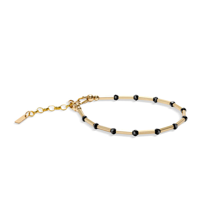 The Scribble & Stone Nightsky Linear Bracelet 3mm features small black spinel stones set between gold segments, finished with an adjustable chain and clasp.