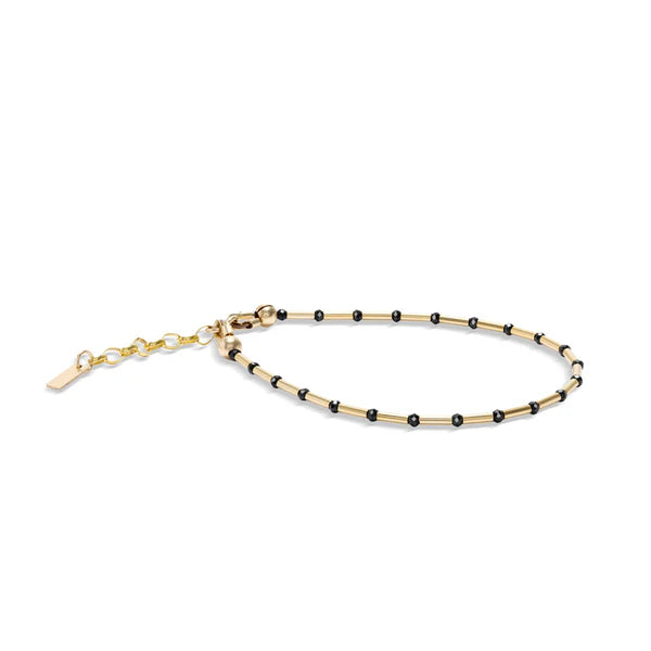 Gold and black beaded bracelet on a white background