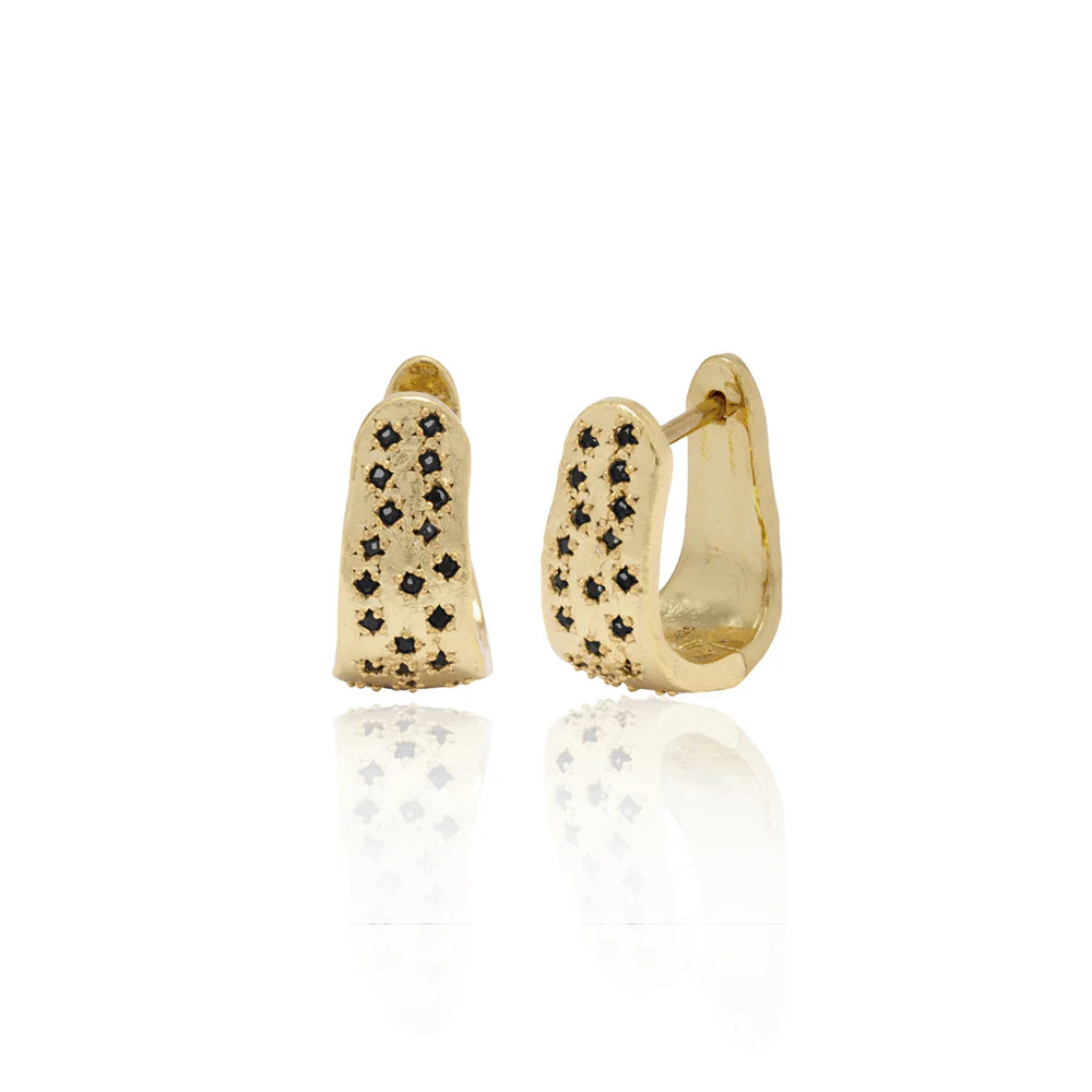 Gold wide hoop style earrings with black gemstones on a white background