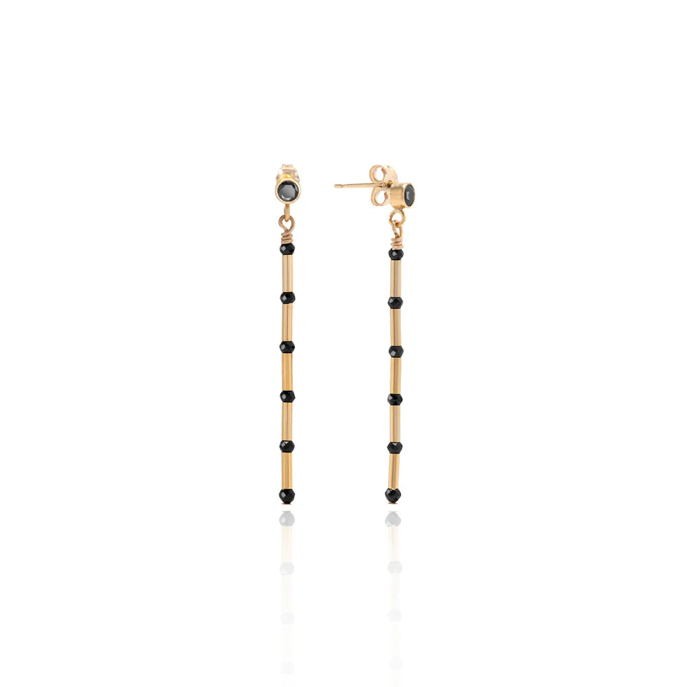 Gold and black beaded earrings on a white background