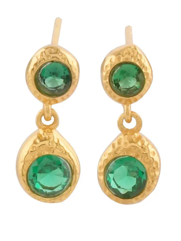The Odessa Earrings by Shyla are gold plated with a hammered finish, featuring two round green stones—one small at the top and a larger dangling crystal below.