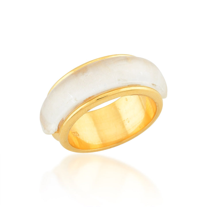 A gold ring with a wide band and a smooth, white inlay encircling its center. The Shyla Orion Ring is designed with a polished finish, and its reflective surface captures light, enhancing its shiny appearance. This stunning piece of hypoallergenic jewelry is displayed on a white background.