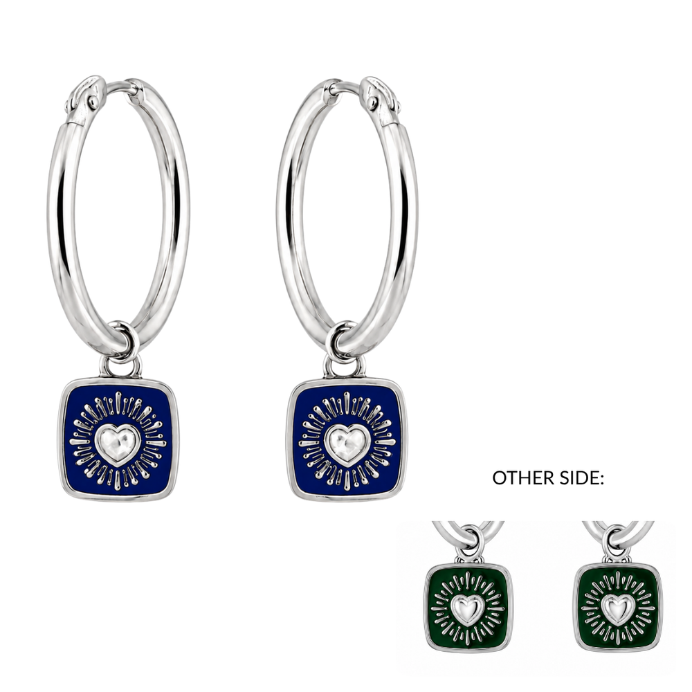 Introducing the Double Sided Keith Haring Claddagh Hoop Earrings from The Collective Dublin: these silver hoop earrings feature square pendants with bold, artistic designs—one side showcases a blue background with a sunburst heart motif, while the reverse displays a similar pattern against a green backdrop. Inspired by Keith Haring and evocative of his energetic style, these unique earrings make a striking statement. The inset highlights the vibrant green side.