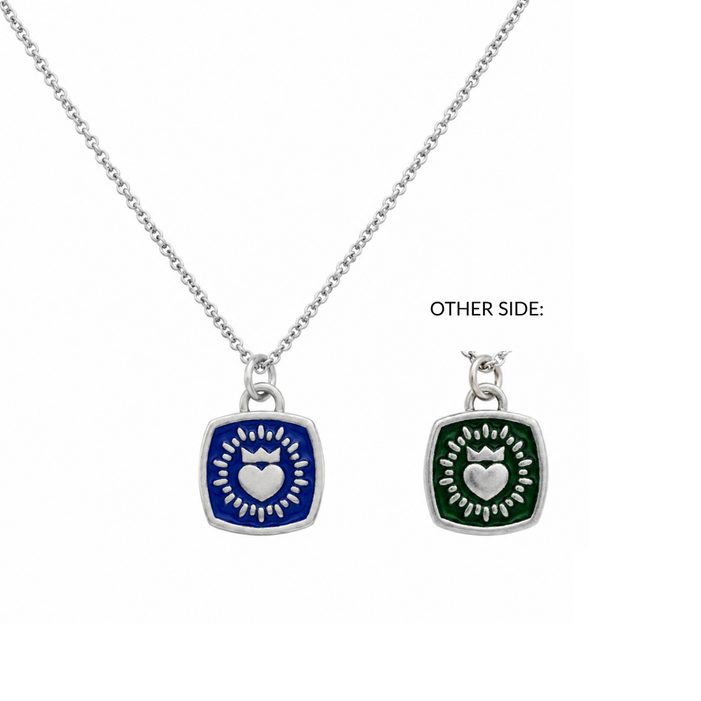 The Collective Dublin's Double Sided Keith Haring Pendant with Chain is a sterling silver Claddagh necklace featuring a square pendant adorned with a white heart and rays on blue enamel, inspired by Keith Haring. The reverse side of this distinctive Irish jewelry piece showcases the same heart and rays motif on green enamel.