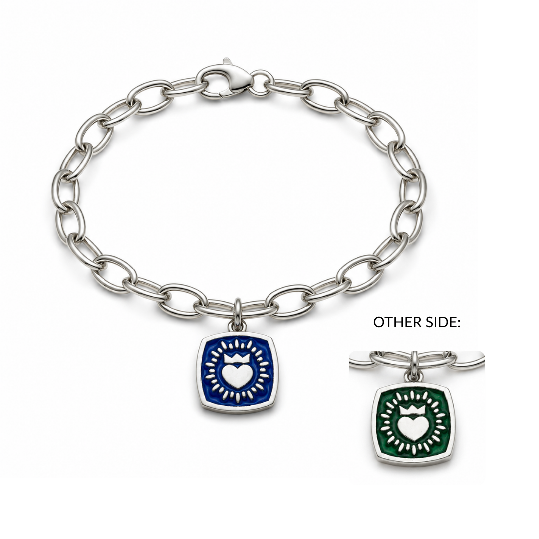 The Double Sided Keith Haring Claddagh On Charm Bracelet by The Collective Dublin is a silver chain bracelet inspired by classic Irish jewelry, featuring a square charm with a white heart and radiant rays. The charm showcases vibrant blue enamel on one side and green enamel on the other, giving a modern twist reminiscent of a sterling silver Claddagh bracelet.
