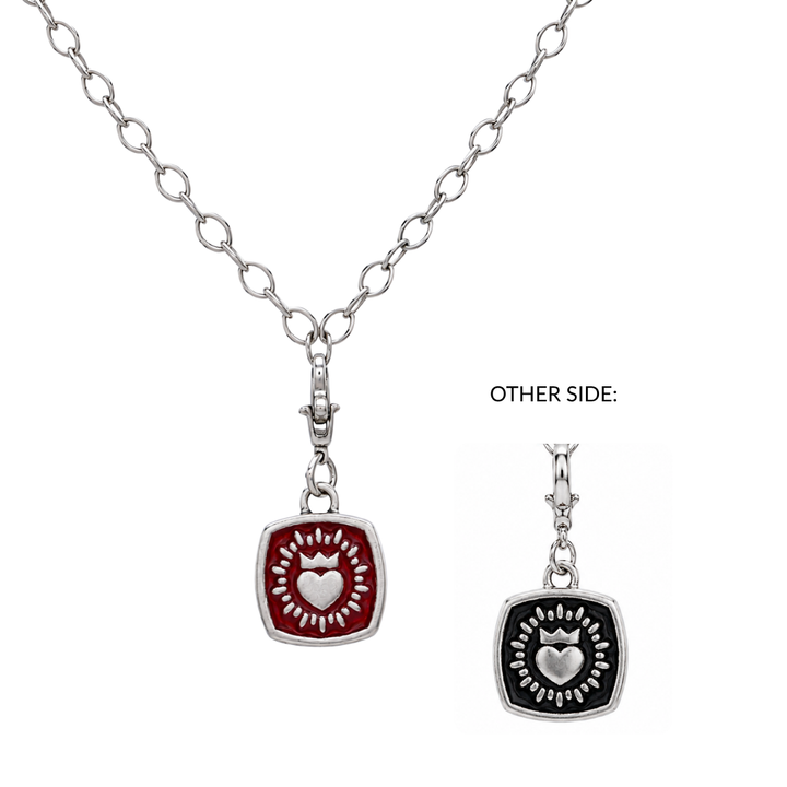 Double Sided Keith Haring Pendant with Chunky Chain by The Collective Dublin. This necklace features a bold silver chain and a square pendant inspired by Irish jewelry traditions. One side of the pendant is red with a silver heart and sunburst, while the other side is black with the same design—just flip it to reveal your style (OTHER SIDE: points to the black design). A modern nod to classic Claddagh necklaces, infused with Keith Haring’s signature artistry.