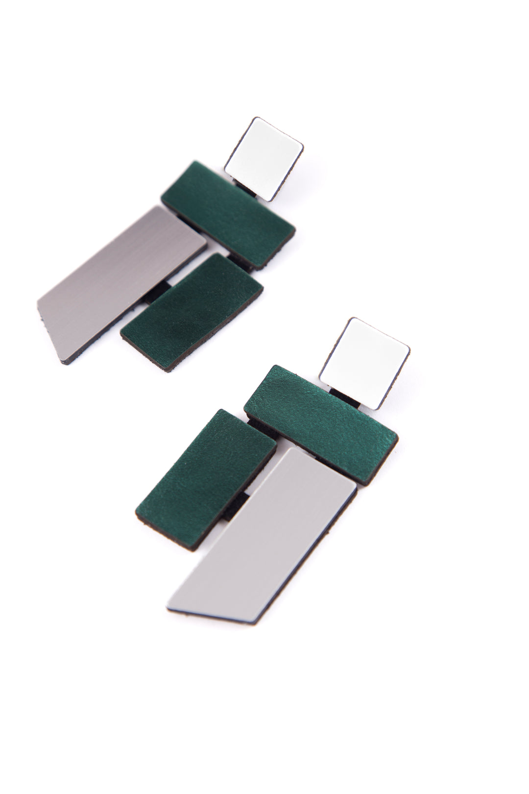 Piet Silver & Green Earrings by Iskin Sisters feature mirrored square studs, green rectangular accents, and angled silver pieces in an abstract Mondrian-inspired design, shown on a white background.