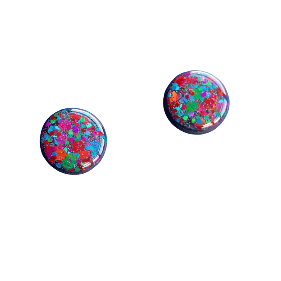 Image of two small, round earrings with a colorful design. The Naoi Party Stud Earrings feature a mix of vibrant colors including red, blue, green, and purple, creating a speckled or confetti-like appearance. They have stainless steel earring posts and are set against a plain white background.