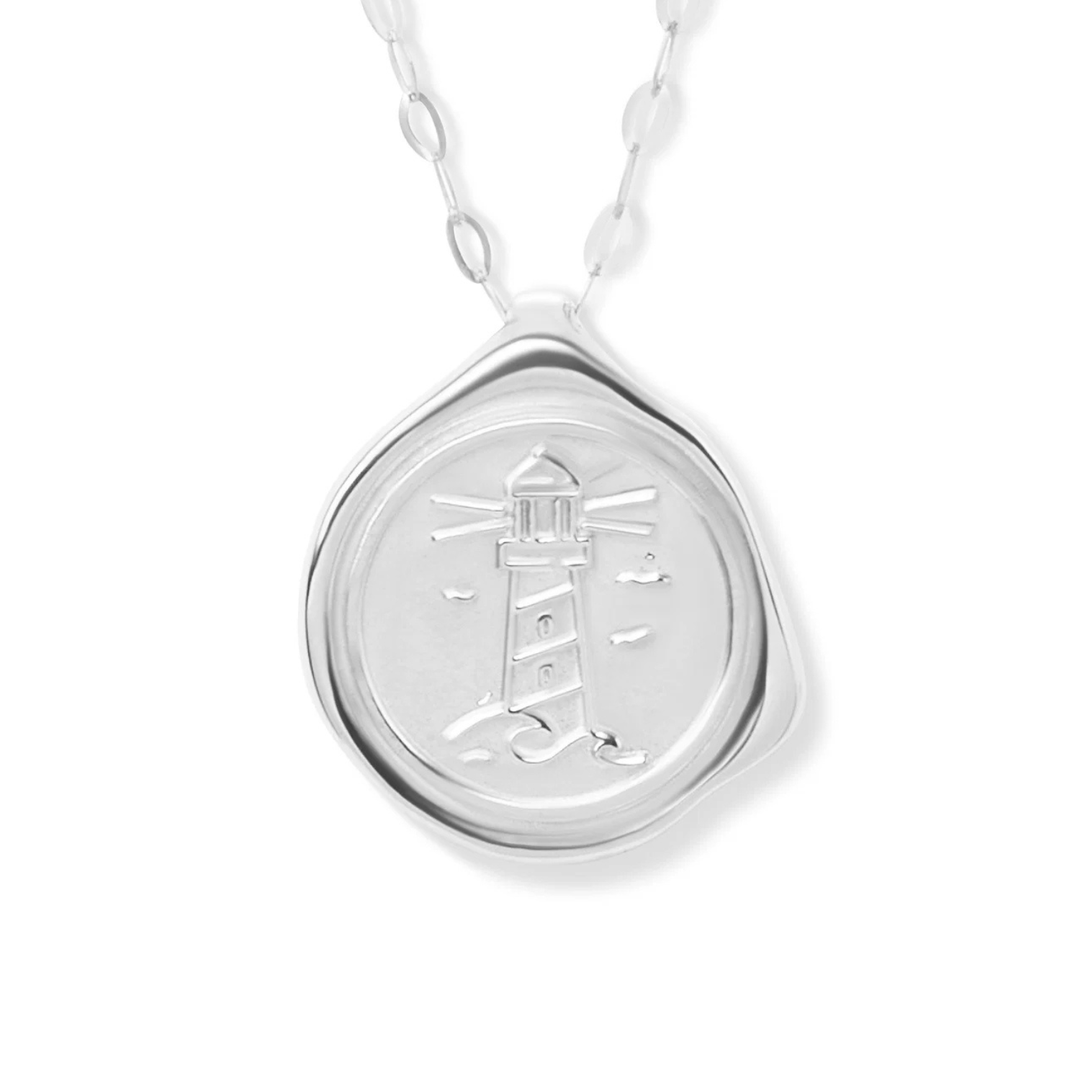 The My Guiding Light Pendant Silver by Ava Jane Jewellery is a sterling silver necklace with a round embossed lighthouse medallion and an organic border, hanging from a delicate oval link chain—a meaningful keepsake.
