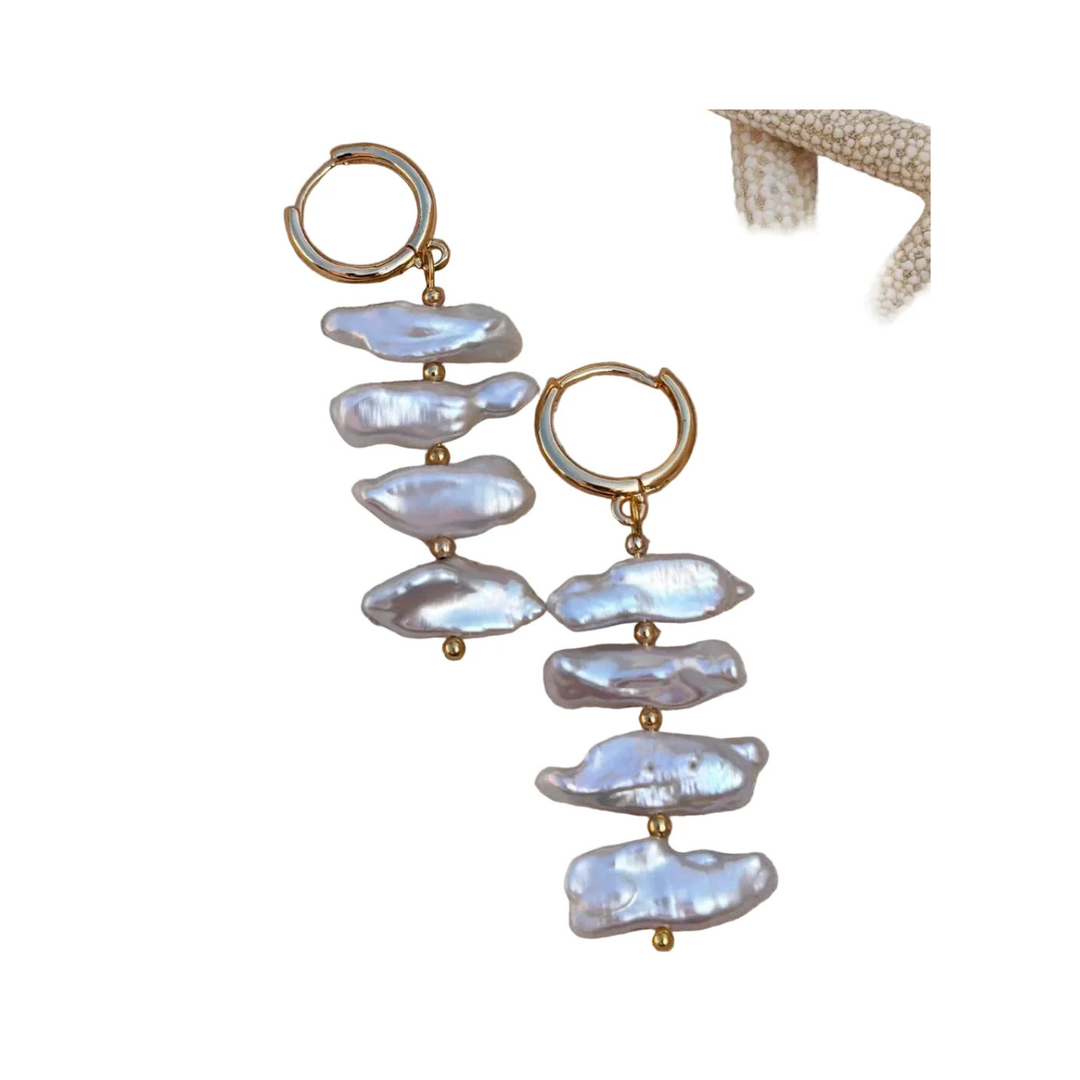 The Perla Sol Earrings by Kybalion Jewellery are gold plated hoops, each featuring three vertically arranged iridescent Biwa pearls, showcased beside a beige starfish on a white background.
