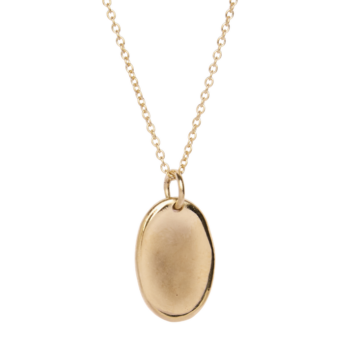 The Collective Dublin’s Personalised Organic Oval Droplet Necklace features a delicate gold chain with an oval-shaped, smooth gold-plated charm pendant suspended from two small loops.