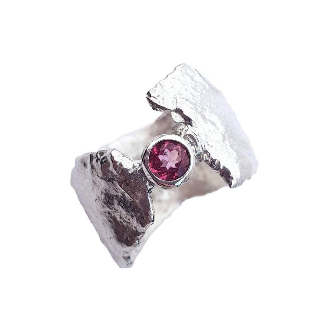 The Caroline Stokesberry-lee Pink Topaz Faerie Tale Ring features a textured silver band with rugged, organic edges and a central round stone—offering bold, whimsical elegance in a modern design.
