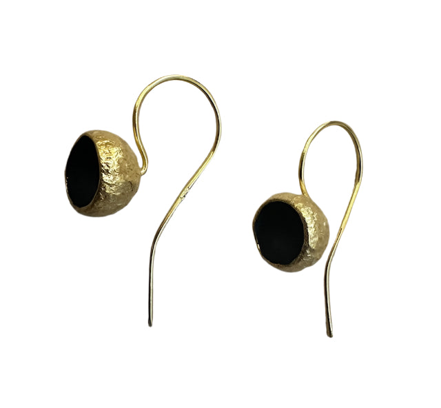 A close-up image of a pair of Acorn Cup Matt Drop Earrings by Georgia Charal. Each earring features a hook design with a round blue stone set in a textured, gold-plated bezel. The plain white background accentuates the matt black and gold colors of the elegant, handmade earrings.