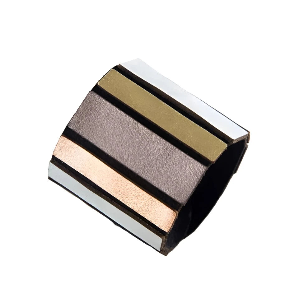 Introducing the Rainbow Round Bracelet Metallic Colours by Iskin Sisters, a wide cuff bracelet crafted from Argentinian leather. It features alternating strips of black, brown, gold, and copper for a modern and minimalist aesthetic. This lightweight jewelry piece stands out beautifully against a white background.