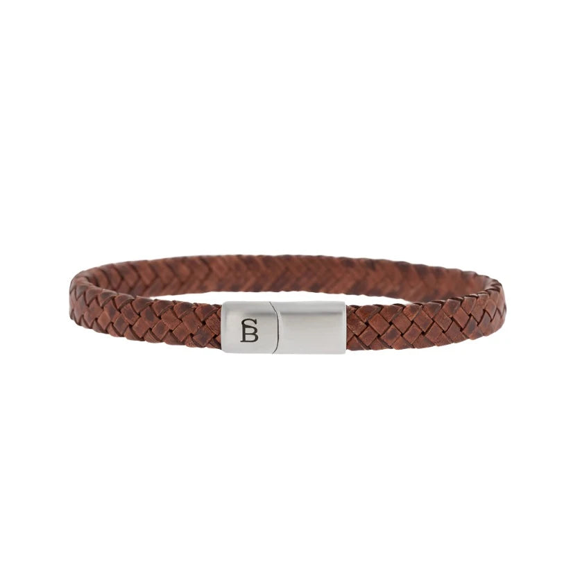 The Riley - Caramel bracelet by Steel and Barnett is a tightly woven brown leather accessory featuring a sleek silver magnetic clasp engraved with a minimalistic letter "B".