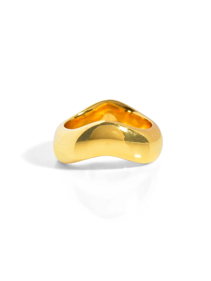 The Rocco Ring by Shyla is a timeless gold piece with a distinctive wavy design and a polished surface that beautifully reflects light, all set against a plain white background to highlight its vibrant golden hue—an essential addition to any stacking ring collection.