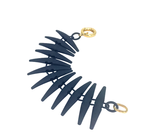 A spiked black bracelet made of 3D printed Nylon with gold clasps on a plain white background. 