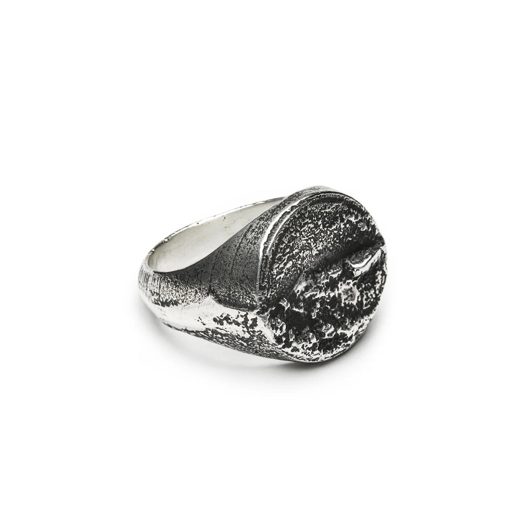 Introducing the Septentrion Round Signet Ring—a textured, handmade 925 silver piece featuring a wide band and a rugged, crater-like surface on top. This artisanal ring highlights expert craftsmanship and offers an organic, distinctive look.