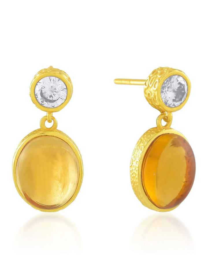 Introducing the Shyla Serena Earrings: a pair of elegant 22 carat gold earrings featuring a round, clear gemstone on top, connected to a larger round amber gemstone below. The hand-hammered settings have intricate designs, enhancing the jewelry's luxurious appearance.