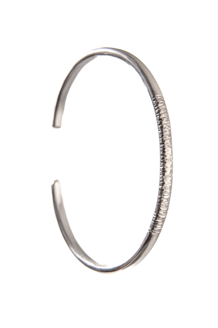 A sterling silver cuff bangle with some bark texture to the front.
