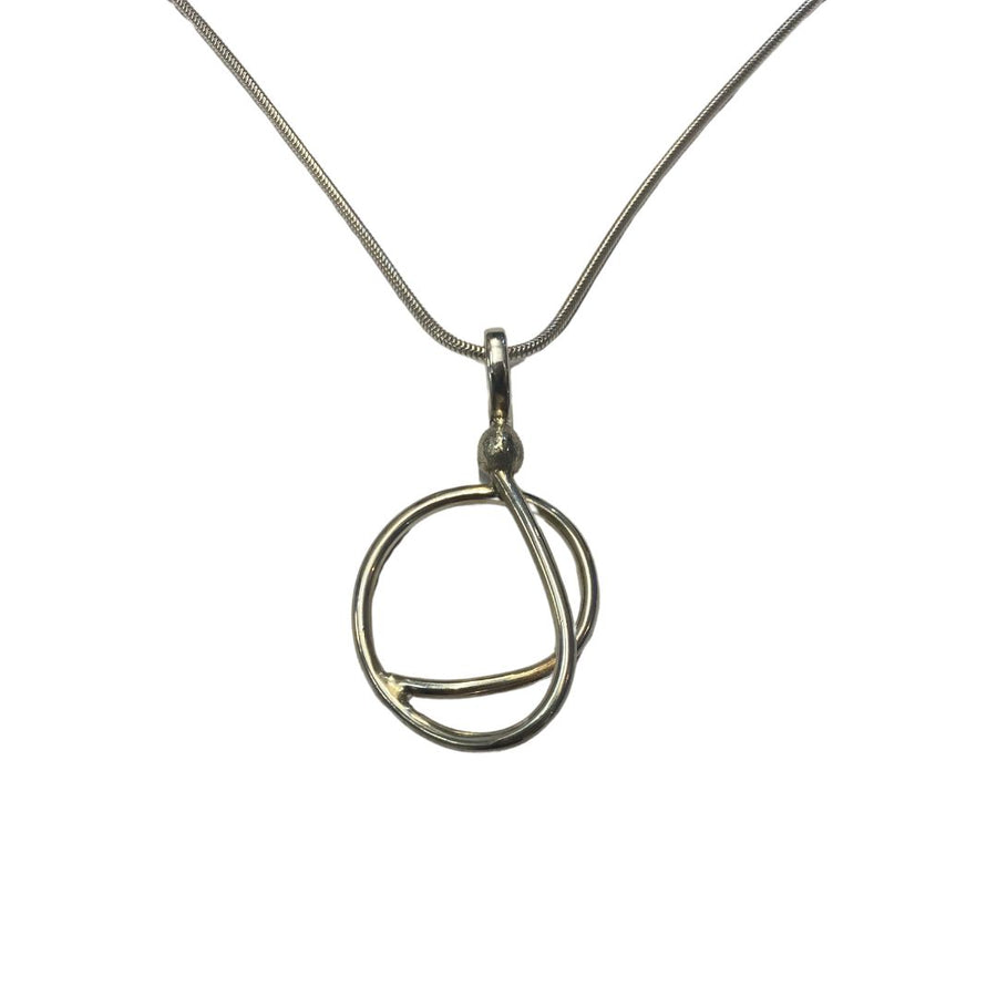 Discover the Sea Honey Pendant by Gallardo & Blaine Designs: a sterling silver necklace featuring an abstract circular pendant with interlocking loops. This minimalist design hangs from a delicate chain, offering a modern, artistic touch.