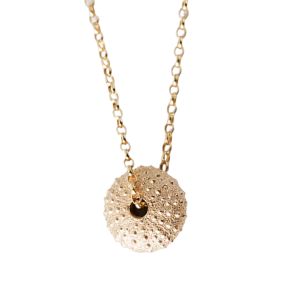 The Jennifer Kinnear Sea Urchin Necklace Small in gold features a textured, round pendant on a delicate chain, elegantly displayed against a white background.