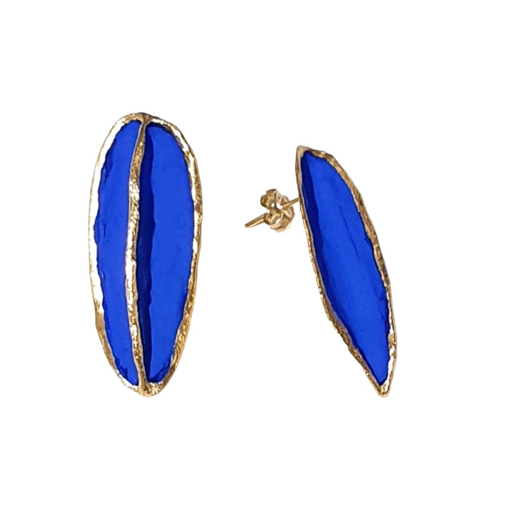 Introducing the Leaf Earrings by Georgia Charal: A pair of handmade earrings featuring a striking bright blue focus with elegant golden accents. Each earring showcases two elongated, almond-shaped sections, divided lengthwise by a thin gold line and framed with a golden border, all set against a pristine white background.