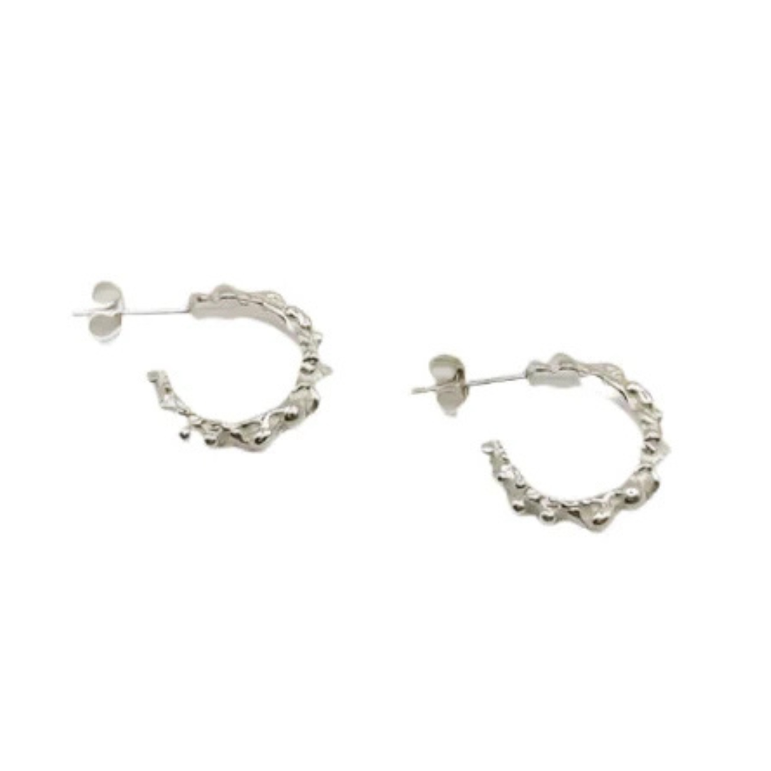 The Seed Hoop Earrings by Inó Jewellery are small, textured sterling silver hoops with post backings, shown on a white background.