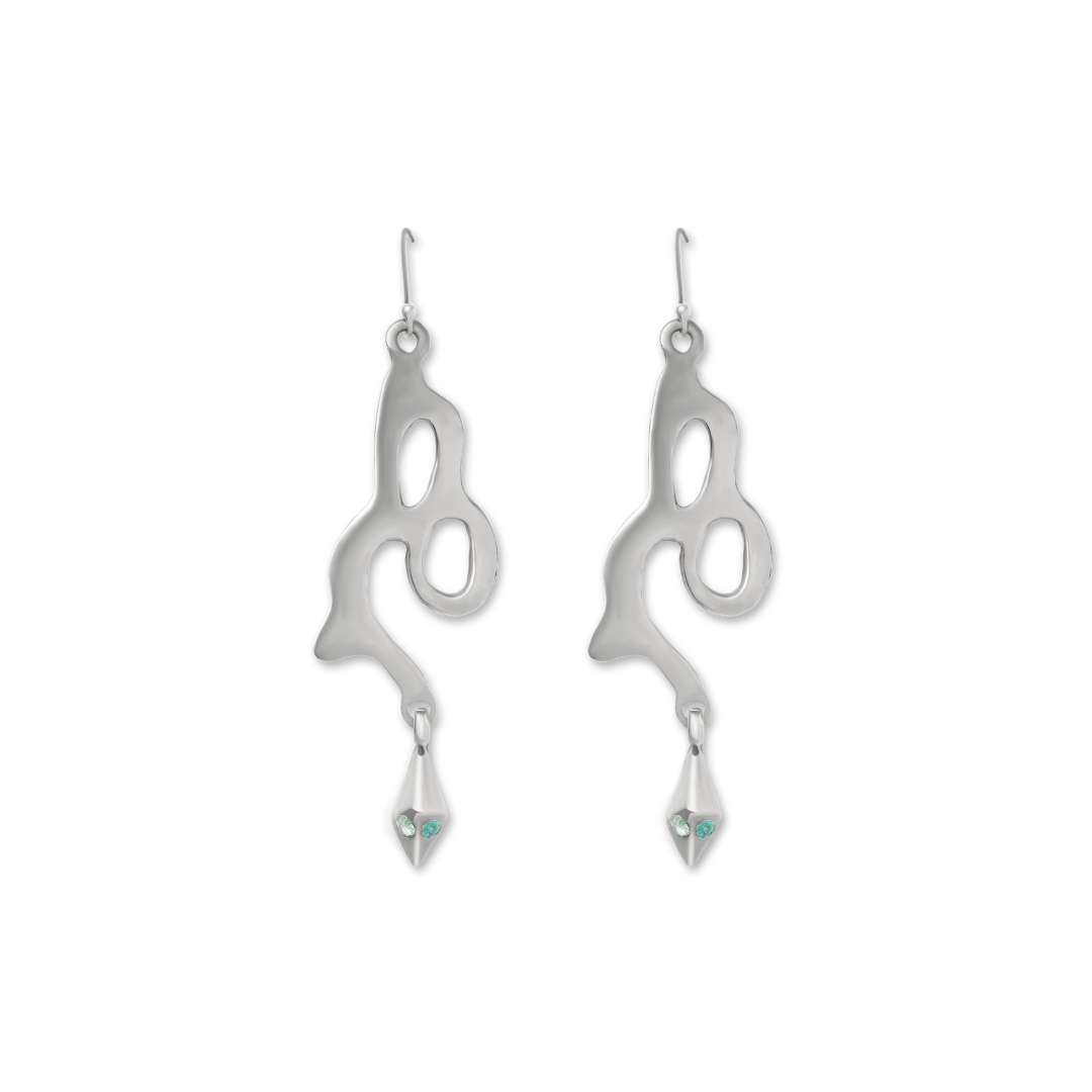 The Serpent Earrings by Madeleine Sculptural Jewellery are silver, abstract-shaped dangles with cut-out designs, pointed tips, and light blue gemstones—crafted sustainably for a stylish, eco-conscious statement.