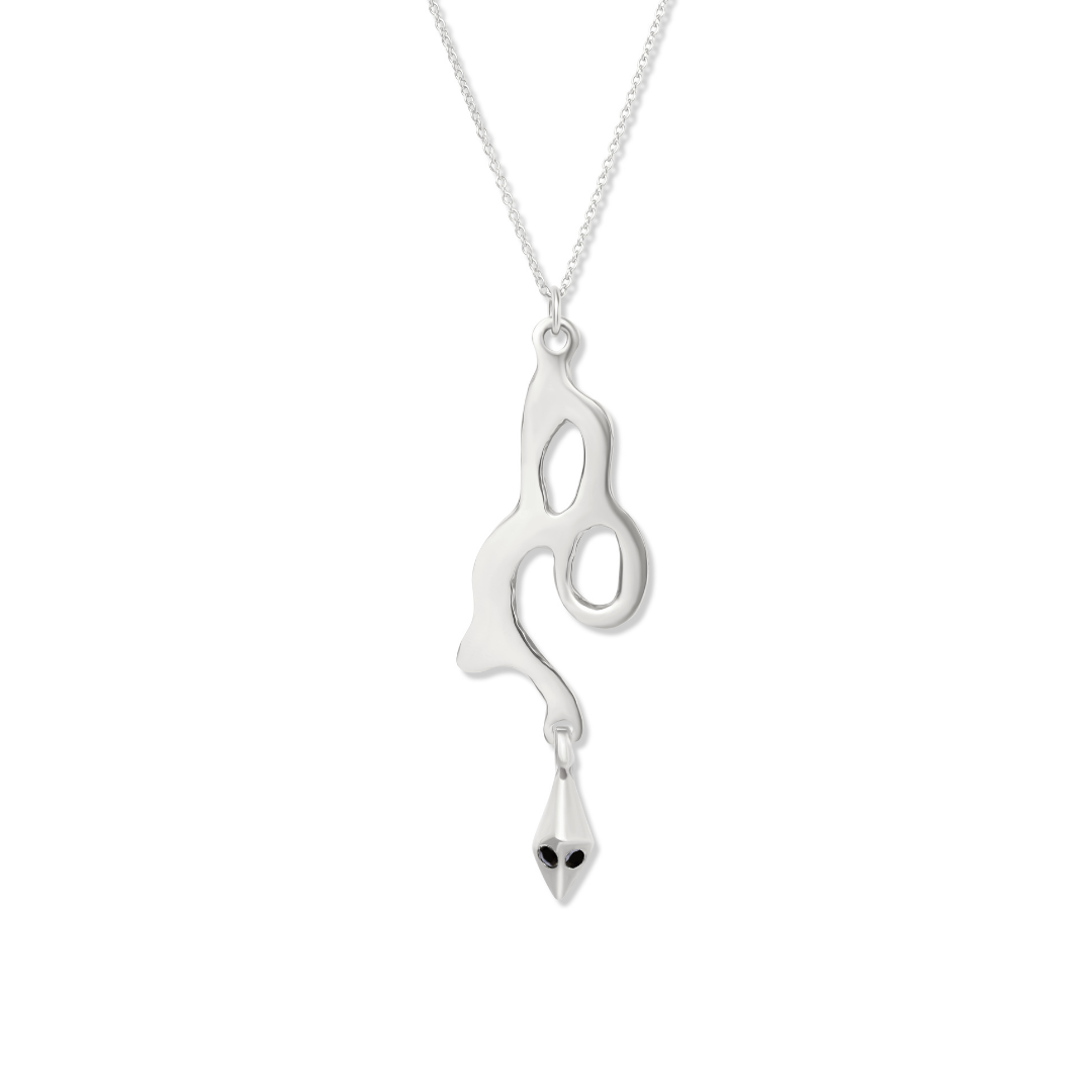 The Serpent Pendant by Madeleine Sculptural Jewellery is a handmade silver necklace with an abstract, fluid-shaped pendant featuring open loops and a teardrop charm with two black eye-like dots, suspended from a delicate silver chain.
